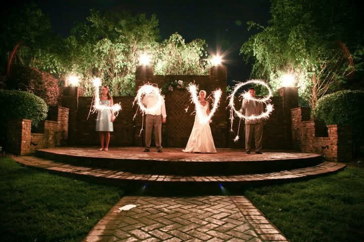 Wedding guests holding sparklers at night